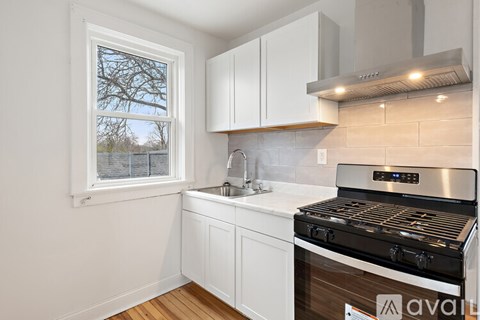 A kitchen with white cabinets and a stove top oven.
