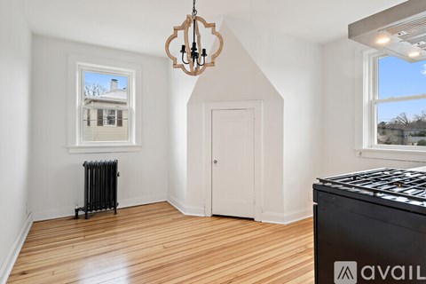 A room with a chandelier, a window with a view, and a radiator.