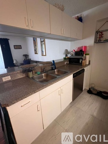 A kitchen with white cabinets and a granite countertop.
