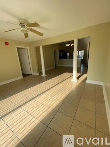 A spacious room with tiled flooring and a ceiling fan.