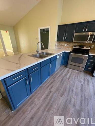 A kitchen with blue cabinets and a white countertop.