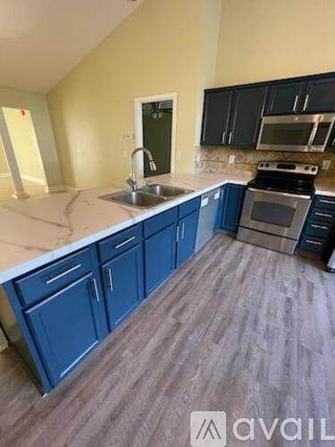 A kitchen with blue cabinets and a white countertop.