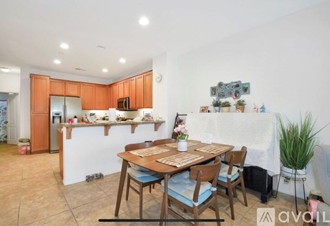 A kitchen with a dining table and chairs.