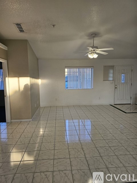 A room with a ceiling fan and tiled flooring.