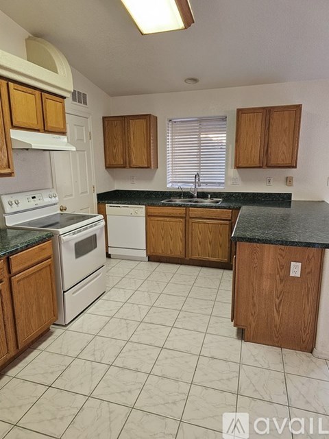 A kitchen with wooden cabinets and a white stove top oven.
