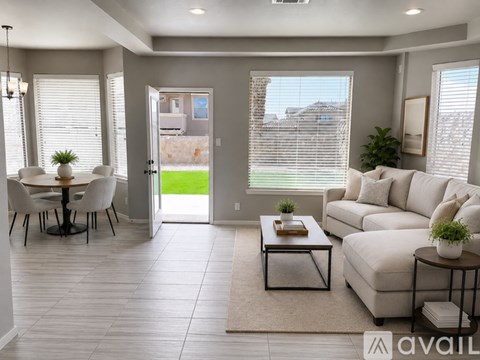A living room with a white couch, a coffee table, and a dining table with chairs.