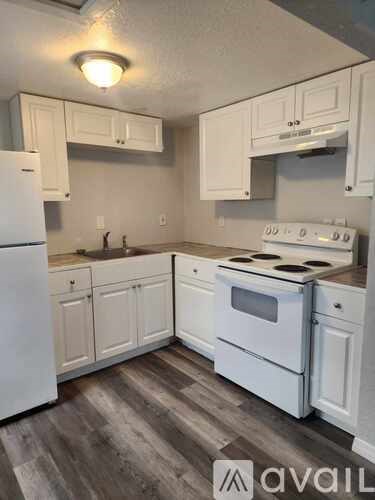 A kitchen with white appliances and cabinets.