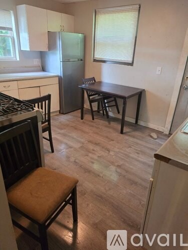 A kitchen with white cabinets and a stove top oven.