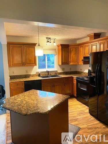 A kitchen with wooden cabinets and granite countertops.