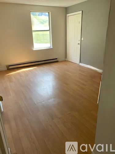 A room with wooden flooring and a window.