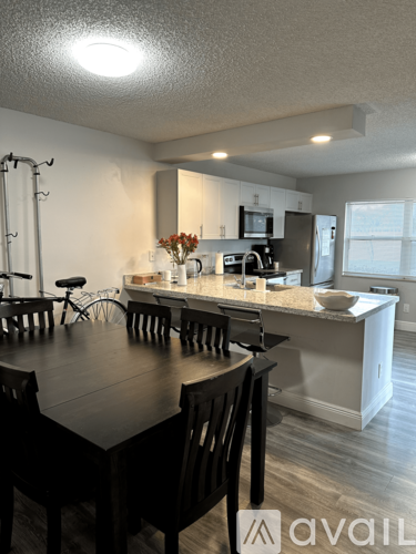 A kitchen with a table and chairs in front of it.