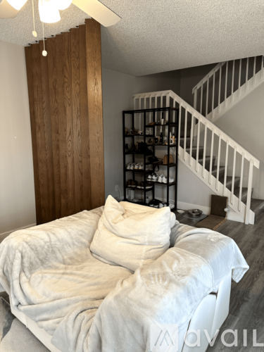 A bedroom with a bed and a staircase.