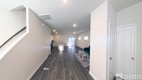 A spacious living room with a rug and a sofa.