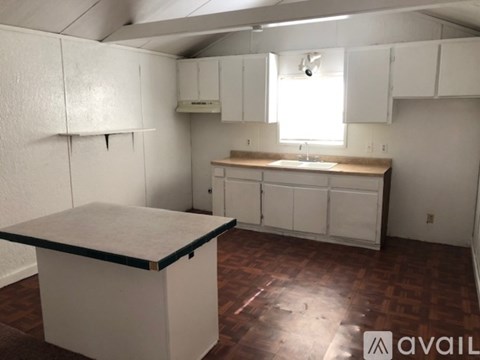 A kitchen with white cabinets and a black counter top.