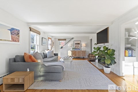 A living room with a grey couch and a wooden side table.