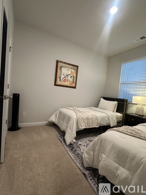 A bedroom with two beds and a painting on the wall.