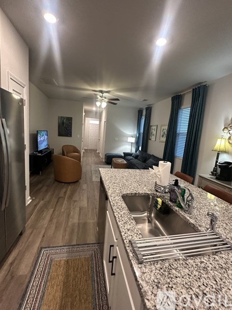 A kitchen with a granite counter top and a sink.
