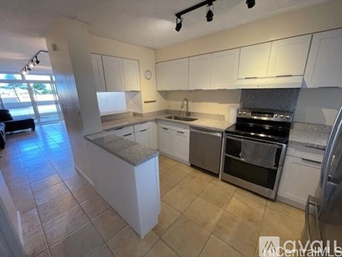 A kitchen with white cabinets and a granite countertop.