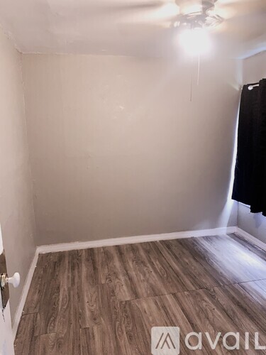 A room with wooden flooring and a ceiling fan.