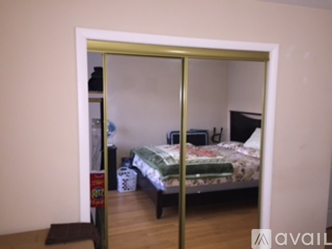 A bedroom with a bed and a mirror with a gold frame.