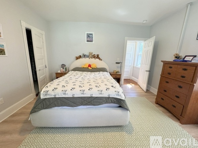 A bedroom with a large bed and a dresser.