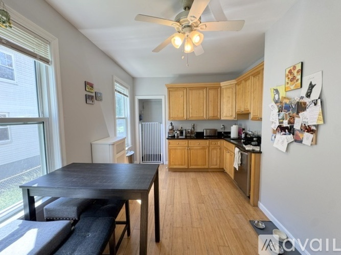 A kitchen with wooden cabinets and a black table.
