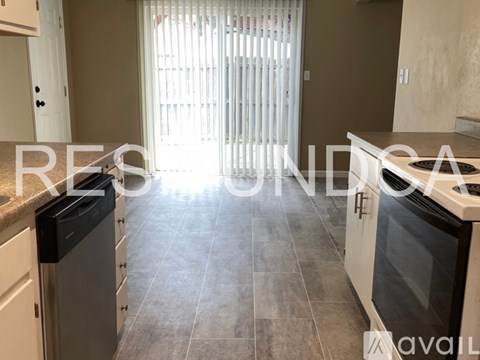A kitchen with a black dishwasher and white appliances.