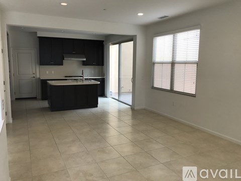 A kitchen with black cabinets and a white island is available for rent.