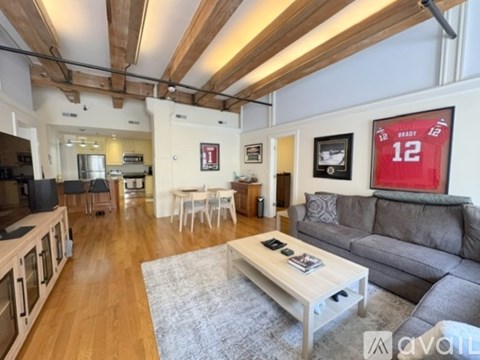 A living room with a grey couch and a coffee table in the middle.