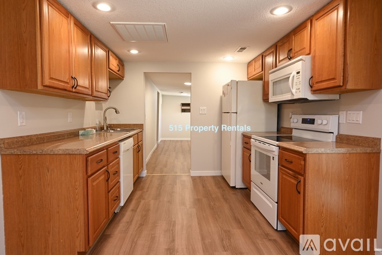 A kitchen with wooden cabinets and white appliances is available for rent.