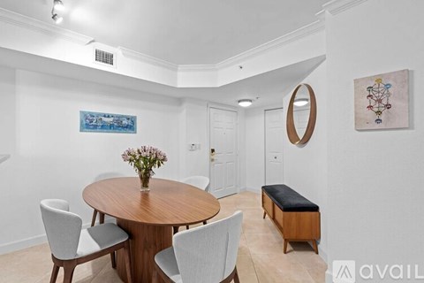 A dining room with a wooden table and chairs.