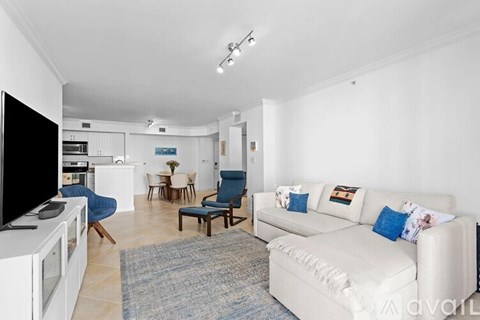 A living room with a white couch and a television.