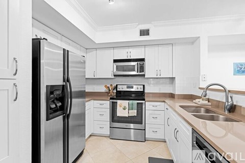A modern kitchen with white cabinets and stainless steel appliances.