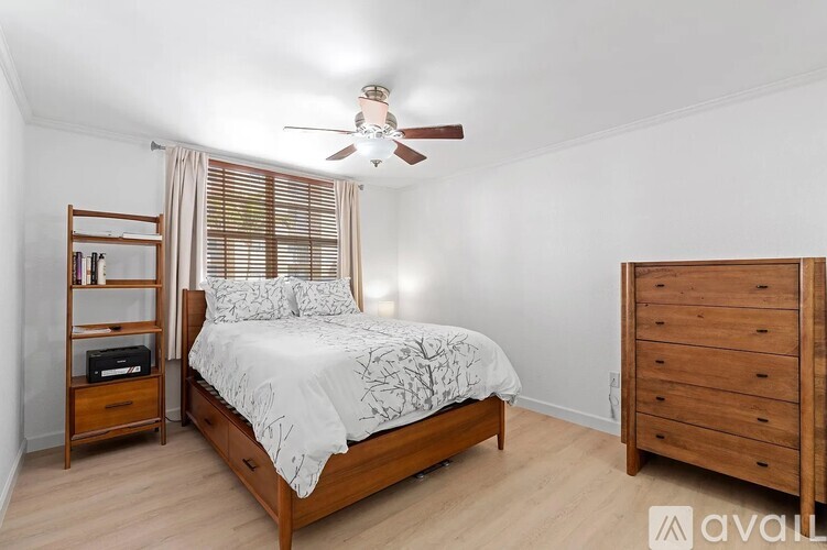 A bedroom with a bed, nightstand, and dresser.