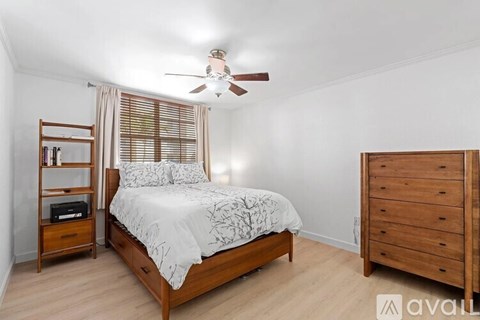 A bedroom with a bed, nightstand, and dresser.