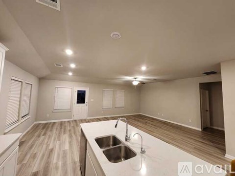 A modern kitchen with a sink and wooden flooring.