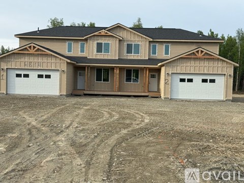 A two-story house with a garage on the side.