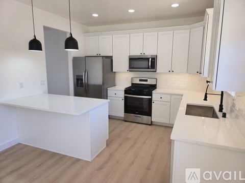 A modern kitchen with white cabinets and a large island.