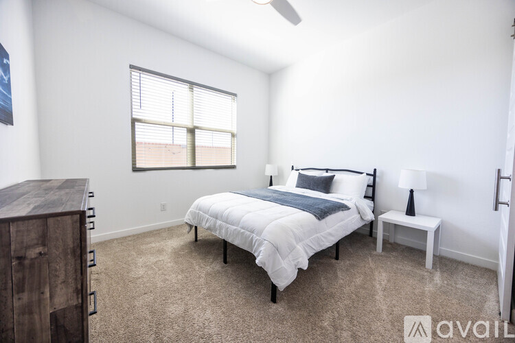 A bedroom with a large bed and a wooden dresser.
