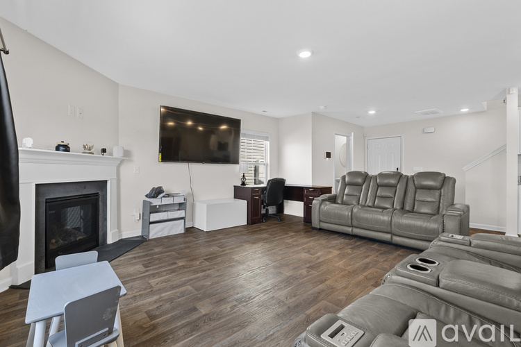 A living room with a fireplace and a grey sofa.