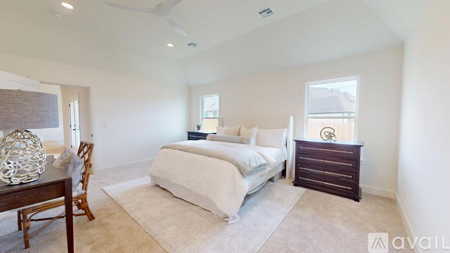 A bedroom with a bed, dresser, and chair.