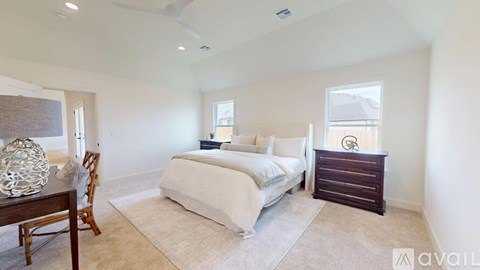 A bedroom with a bed, dresser, and chair.