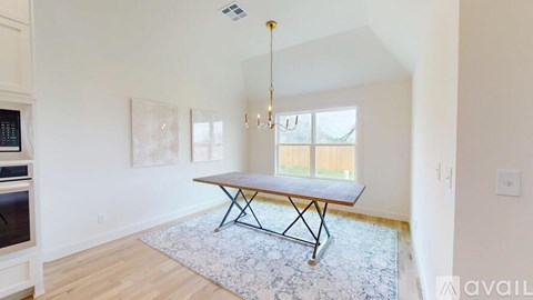 A dining room with a table and chairs.