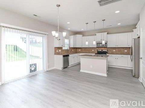 A spacious kitchen with white cabinets and a central island.