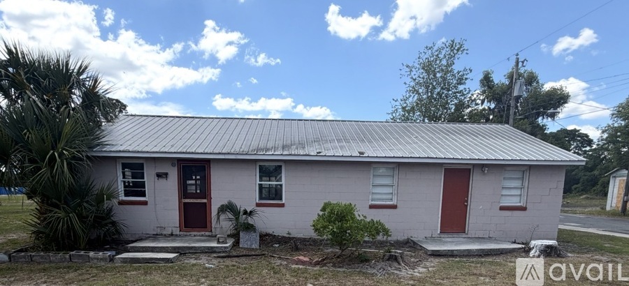 A small house with a red door and a metal roof.
