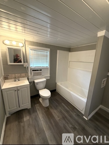 A bathroom with a toilet, sink, and bathtub.