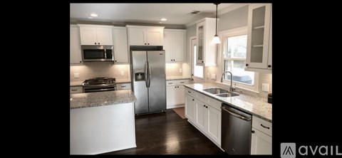 A kitchen with white cabinets and a granite countertop.