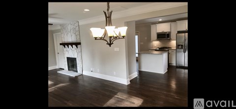 A large, spacious living room with a fireplace and a chandelier.