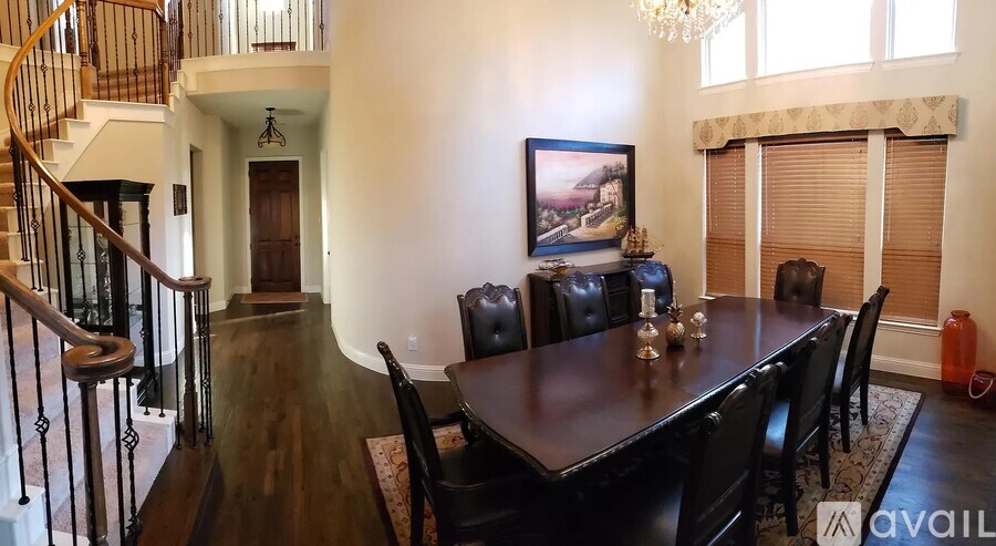 A dining room with a wooden table and chairs.