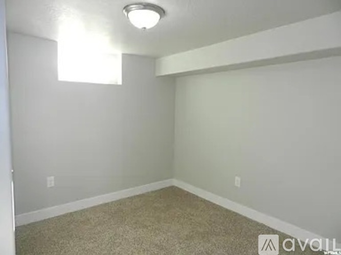 A room with a carpeted floor and a window.